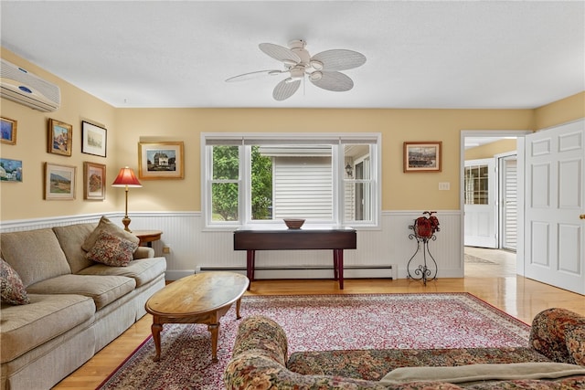 435 Allen Ave, South Kingstown, RI 02879 - living room with a baseboard radiator, a wainscoted wall, a wall mounted AC, a ceiling fan, and light wood finished floors