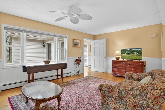 435 Allen Ave, South Kingstown, RI 02879 - living room with wainscoting, wood finished floors, ceiling fan, and a baseboard radiator