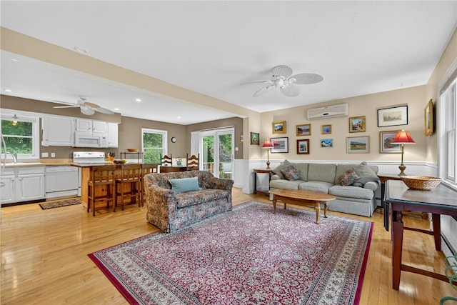 435 Allen Ave, South Kingstown, RI 02879 - living area with ceiling fan, an AC wall unit, light wood-style floors, a wainscoted wall, and recessed lighting