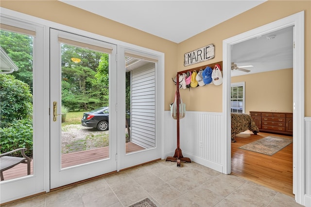 435 Allen Ave, South Kingstown, RI 02879 - doorway to outside with healthy amount of natural light, a wainscoted wall, a ceiling fan, and light tile patterned floors