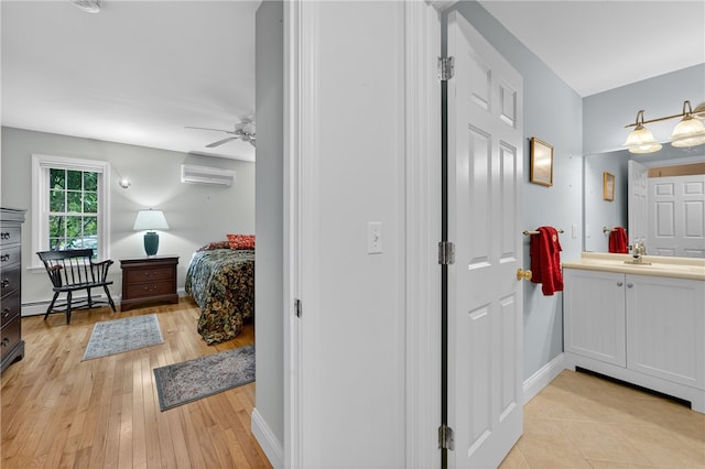 435 Allen Ave, South Kingstown, RI 02879 - bathroom with vanity, ceiling fan, an AC wall unit, wood finished floors, and a baseboard radiator