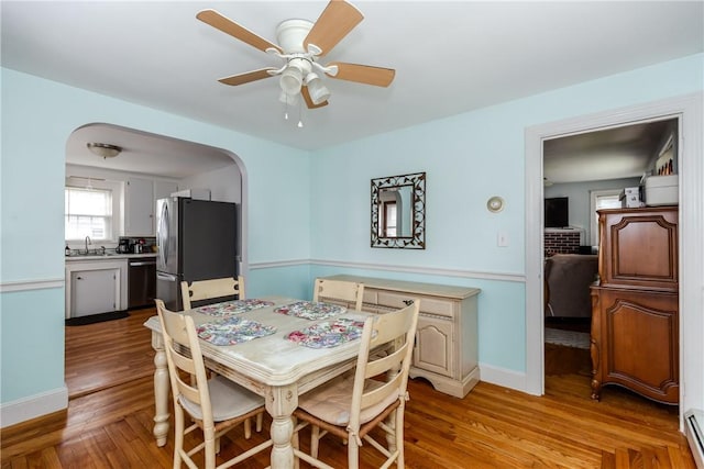 36 Walton St, Providence, RI 02908 - dining space featuring arched walkways, baseboard heating, light wood-style flooring, and ceiling fan