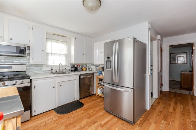 36 Walton St, Providence, RI 02908 - kitchen featuring appliances with stainless steel finishes, light countertops, white cabinets, and decorative backsplash