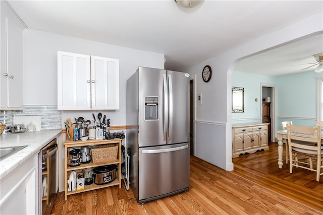 36 Walton St, Providence, RI 02908 - kitchen featuring stainless steel appliances, light wood-style floors, white cabinetry, light countertops, and arched walkways