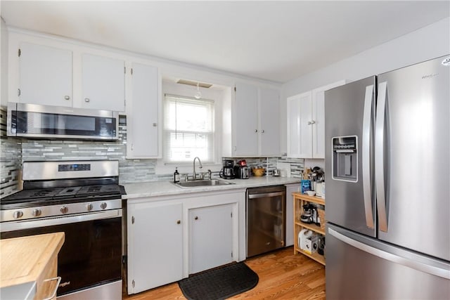 36 Walton St, Providence, RI 02908 - kitchen with stainless steel appliances, light countertops, white cabinetry, and decorative backsplash