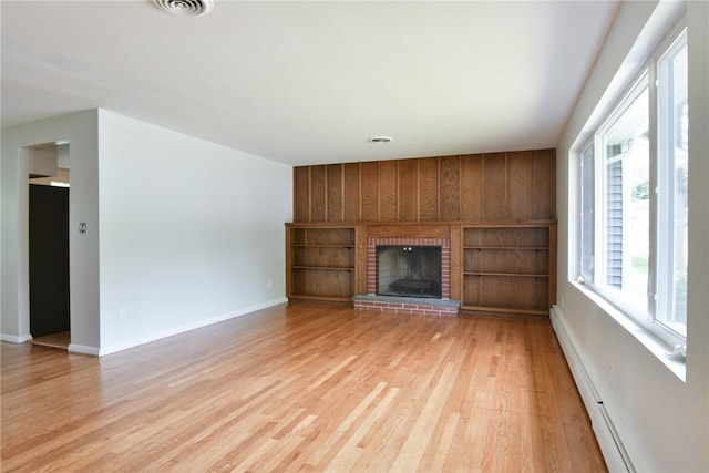 44 Cindy Ln, Warwick, RI 02886 - unfurnished living room with a baseboard heating unit, light wood-style flooring, a fireplace, and wood walls