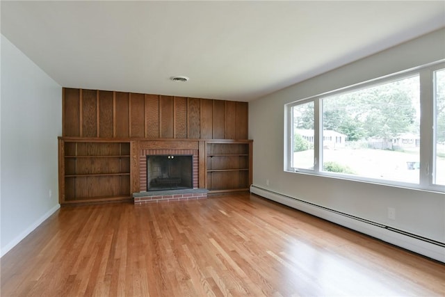 44 Cindy Ln, Warwick, RI 02886 - unfurnished living room with a baseboard heating unit, plenty of natural light, light wood-type flooring, a fireplace, and wood walls