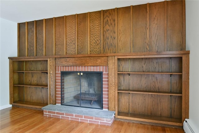 44 Cindy Ln, Warwick, RI 02886 - detailed view of a brick fireplace, a baseboard radiator, and wood finished floors