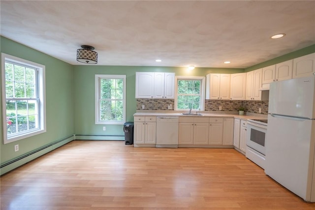 196 William Henry Rd, Scituate, RI 02857 - kitchen with white appliances, white cabinets, light wood-style floors, light countertops, and tasteful backsplash