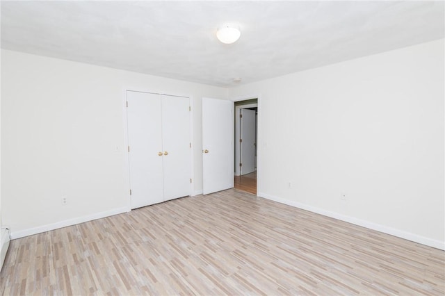 196 William Henry Rd, Scituate, RI 02857 - unfurnished bedroom with light wood finished floors, a closet, and a baseboard heating unit