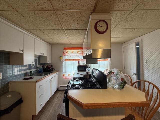 141 Pomona Ave, Providence, RI 02908 - kitchen with a paneled ceiling, black appliances, dark wood-style flooring, white cabinets, and wall chimney range hood