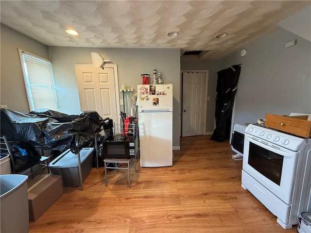 141 Pomona Ave, Providence, RI 02908 - kitchen featuring white appliances, light wood-type flooring, and heating unit