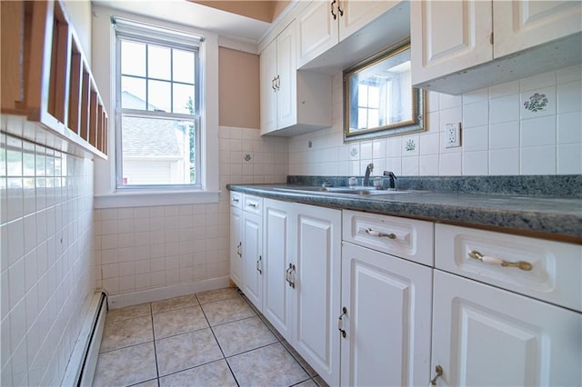 1397 Chalkstone Ave, Providence, RI 02909 - kitchen with baseboard heating, white cabinetry, healthy amount of natural light, dark countertops, and tile walls