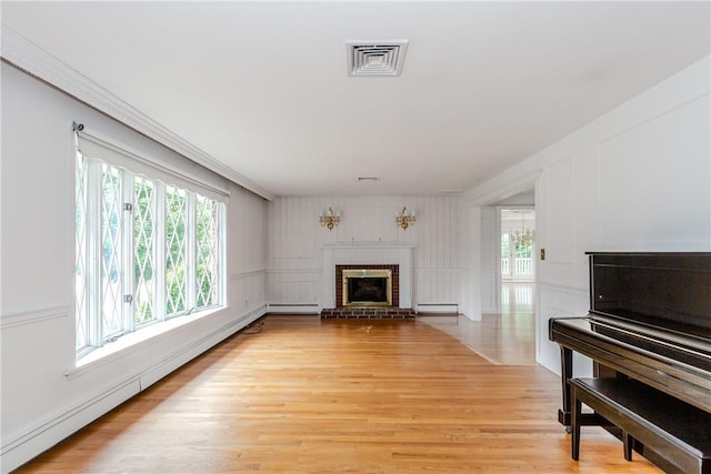 11 Macintosh Dr, Smithfield, RI 02828 - living area featuring baseboard heating, a brick fireplace, healthy amount of natural light, and a decorative wall