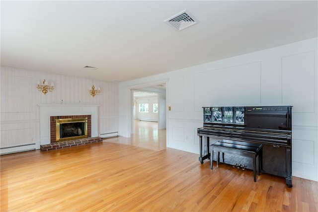 11 Macintosh Dr, Smithfield, RI 02828 - living room featuring a baseboard radiator, wood finished floors, a decorative wall, a brick fireplace, and baseboard heating