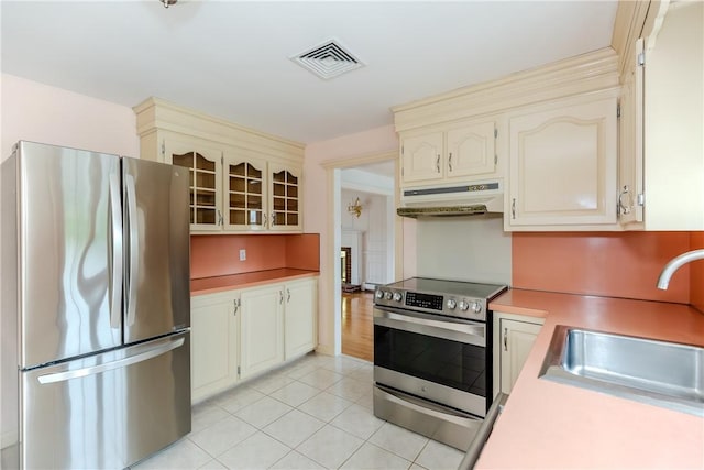 11 Macintosh Dr, Smithfield, RI 02828 - kitchen featuring stainless steel appliances, under cabinet range hood, light countertops, light tile patterned flooring, and cream cabinets