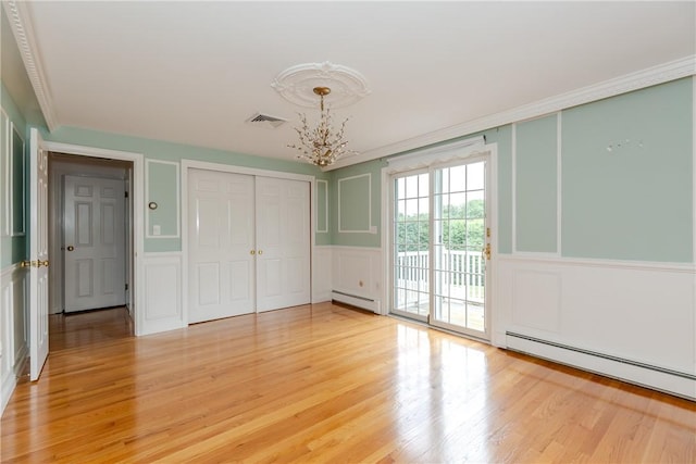 11 Macintosh Dr, Smithfield, RI 02828 - unfurnished bedroom featuring a decorative wall, a baseboard heating unit, access to outside, a chandelier, and light wood-style flooring