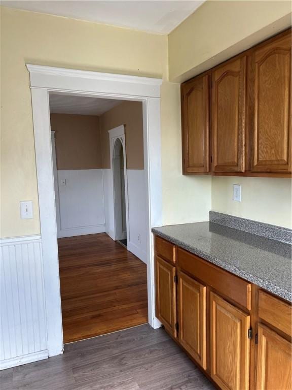 877 Central Ave, Pawtucket, RI 02861 - kitchen with dark wood-style flooring, brown cabinets, and a wainscoted wall