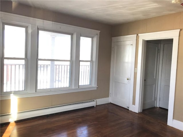 877 Central Ave, Pawtucket, RI 02861 - unfurnished bedroom featuring baseboard heating and dark wood-style flooring