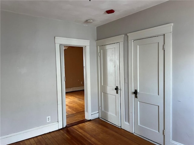 877 Central Ave, Pawtucket, RI 02861 - unfurnished bedroom featuring dark wood-style flooring and a baseboard heating unit