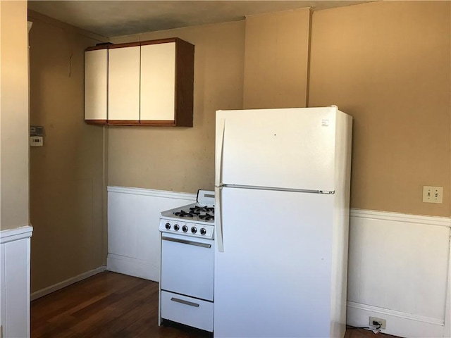 877 Central Ave, Pawtucket, RI 02861 - kitchen featuring white appliances, a wainscoted wall, dark wood-style floors, a decorative wall, and white cabinets