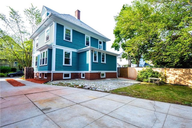 192 Lenox Ave, Providence, RI 02907 - back of property with a chimney, driveway, and a patio area