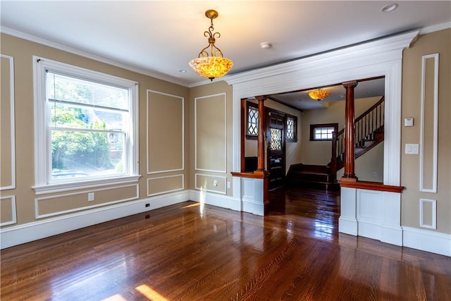 192 Lenox Ave, Providence, RI 02907 - unfurnished dining area with plenty of natural light, wood finished floors, a decorative wall, crown molding, and ornate columns