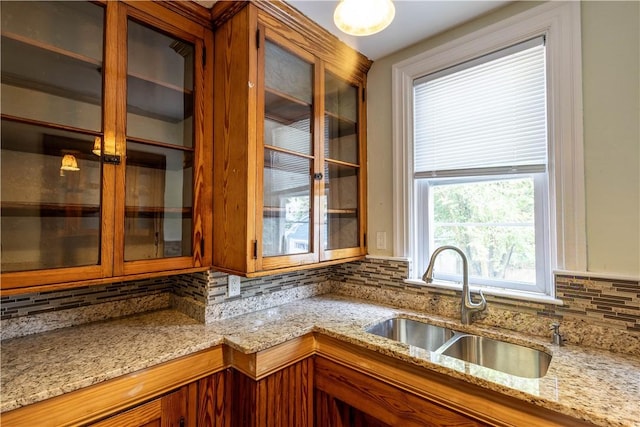 192 Lenox Ave, Providence, RI 02907 - kitchen featuring brown cabinets, tasteful backsplash, glass insert cabinets, and light stone counters