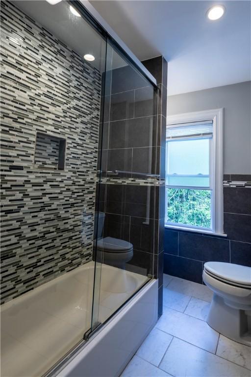 192 Lenox Ave, Providence, RI 02907 - full bathroom with tile walls, tile patterned floors, bath / shower combo with glass door, and recessed lighting