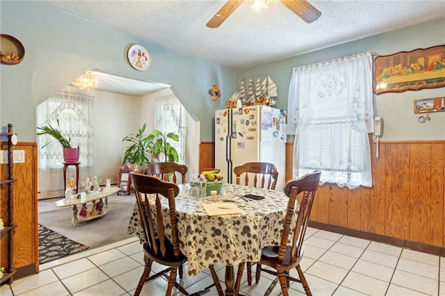 22 Parsons Ave, East Providence, RI 02914 - dining space with a textured ceiling, a ceiling fan, light tile patterned floors, wainscoting, and wood walls