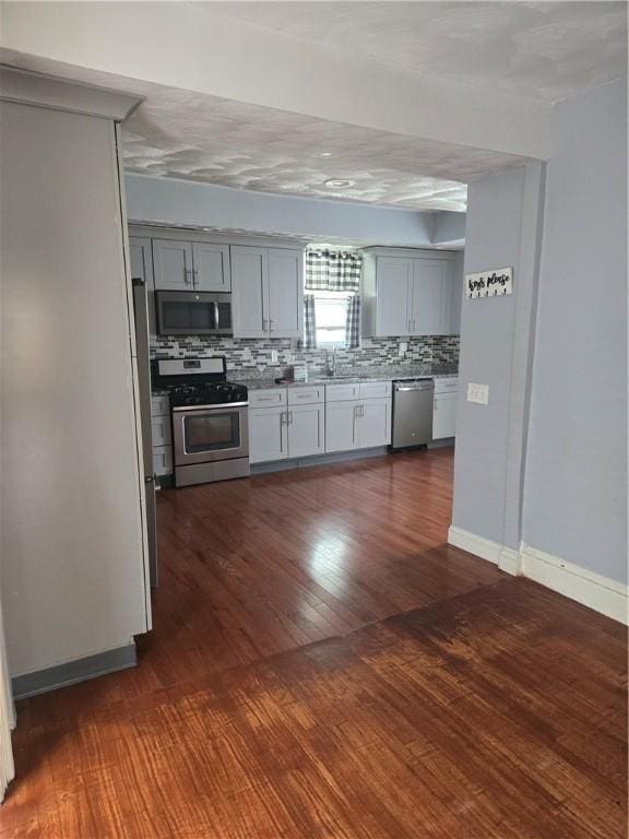 45 Harrison St, Pawtucket, RI 02860 - kitchen featuring appliances with stainless steel finishes, gray cabinets, backsplash, light countertops, and dark wood-type flooring