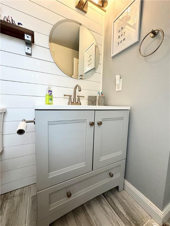 8 Orchard St, West Warwick, RI 02893 - bathroom featuring wood finished floors, vanity, and wooden walls