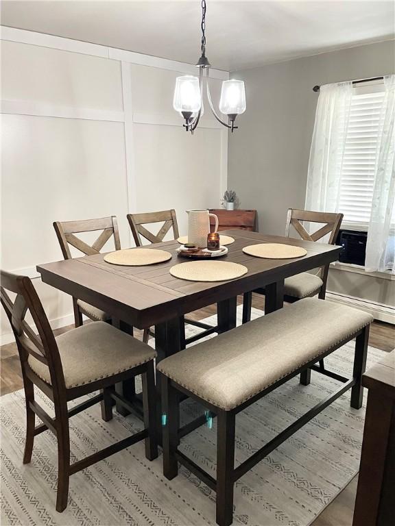 8 Orchard St, West Warwick, RI 02893 - dining space with light wood-style flooring, a chandelier, and a baseboard radiator