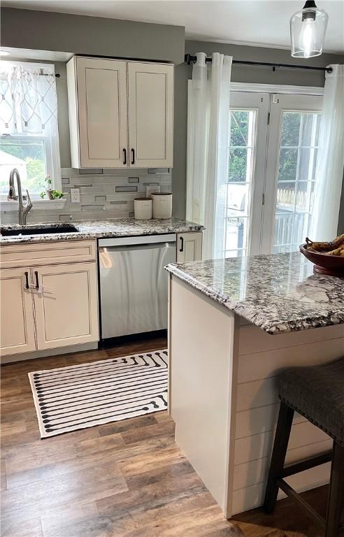 8 Orchard St, West Warwick, RI 02893 - kitchen with stainless steel dishwasher, white cabinets, light stone countertops, and wood finished floors