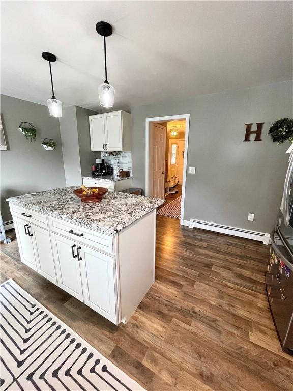 8 Orchard St, West Warwick, RI 02893 - kitchen with a baseboard heating unit, white cabinetry, dark wood-type flooring, and hanging light fixtures