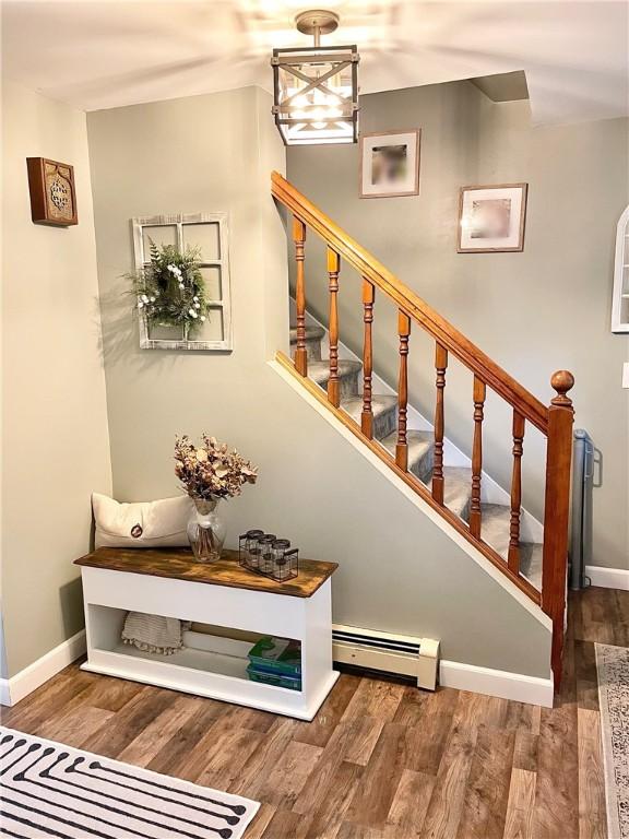 8 Orchard St, West Warwick, RI 02893 - stairway featuring a baseboard heating unit and wood finished floors