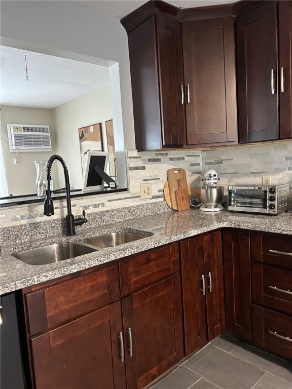 565 Quaker Ln Unit 101, West Warwick, RI 02893 - kitchen featuring decorative backsplash, light stone countertops, an AC wall unit, and dark brown cabinetry