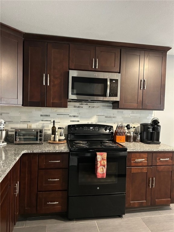 565 Quaker Ln Unit 101, West Warwick, RI 02893 - kitchen featuring black / electric stove, stainless steel microwave, tasteful backsplash, and light tile patterned flooring