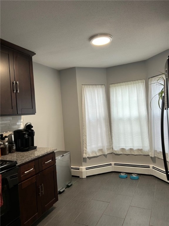 565 Quaker Ln Unit 101, West Warwick, RI 02893 - kitchen featuring electric range oven, a baseboard heating unit, dark brown cabinets, backsplash, and light stone countertops
