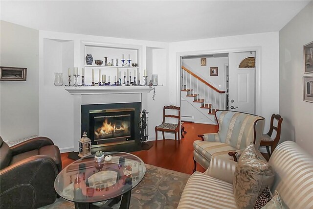 60 Tower Hill Rd, Tiverton, RI 02878 - living room featuring a baseboard heating unit, wood finished floors, a glass covered fireplace, and stairway