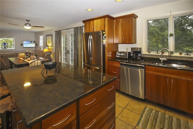 60 Tower Hill Rd, Tiverton, RI 02878 - kitchen with appliances with stainless steel finishes, light tile patterned floors, a ceiling fan, a kitchen island, and dark stone counters