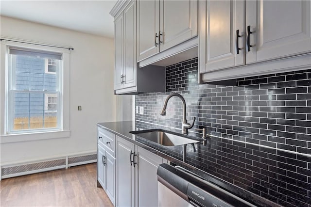 68 Friendly Rd, Cranston, RI 02910 - kitchen featuring tasteful backsplash, light wood finished floors, dishwasher, dark stone countertops, and a baseboard heating unit