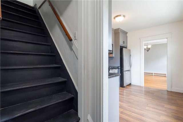 68 Friendly Rd, Cranston, RI 02910 - staircase featuring wood finished floors, a chandelier, and a baseboard heating unit