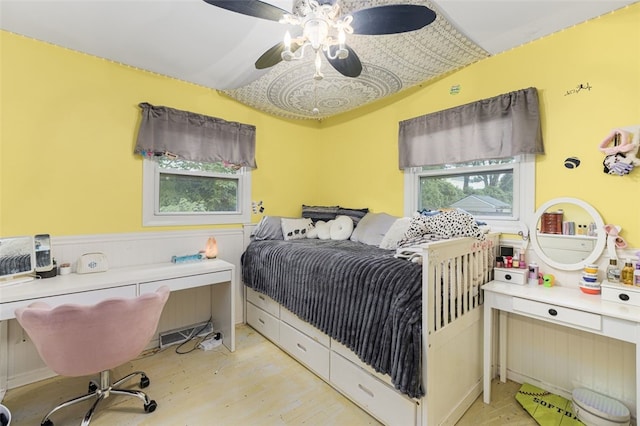27 Nixon St, Cumberland, RI 02864 - bedroom with light wood-type flooring, a desk, a ceiling fan, and a wainscoted wall