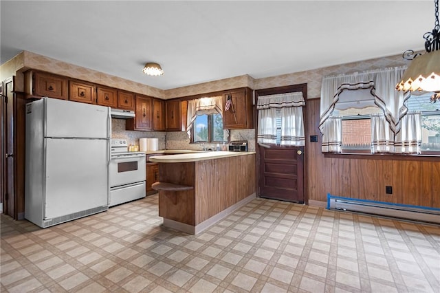 321 Beckwith St, Cranston, RI 02910 - kitchen featuring white appliances, under cabinet range hood, light floors, a peninsula, and light countertops