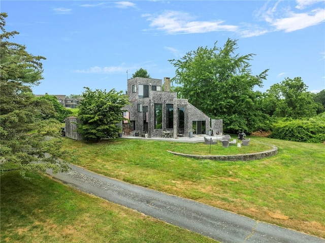 668 Indian Ave, Middletown, RI 02842 - rear view of property featuring a lawn and a patio area