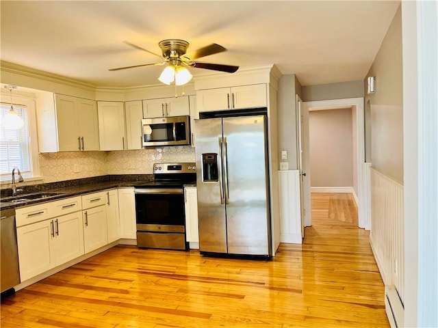 74 Leslie St, Cranston, RI 02910 - kitchen featuring appliances with stainless steel finishes, light wood finished floors, ceiling fan, backsplash, and wainscoting