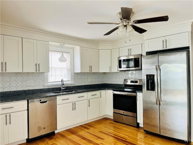74 Leslie St, Cranston, RI 02910 - kitchen with stainless steel appliances, ceiling fan, light wood-style floors, backsplash, and ornamental molding
