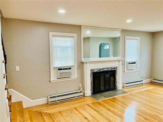 74 Leslie St, Cranston, RI 02910 - unfurnished living room featuring a baseboard heating unit, a fireplace with flush hearth, wood finished floors, cooling unit, and plenty of natural light