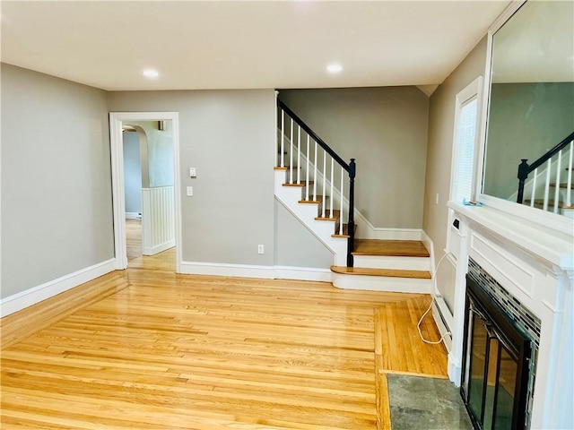 74 Leslie St, Cranston, RI 02910 - unfurnished living room featuring stairway, wood finished floors, recessed lighting, a fireplace with flush hearth, and arched walkways